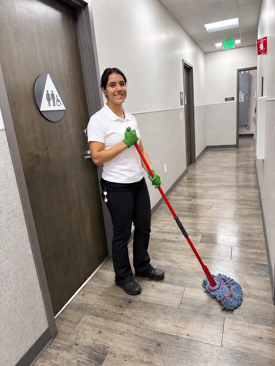 Team member mopping a hallway outside a restroom